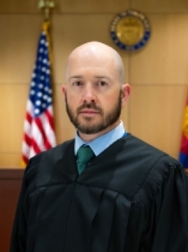 Photo of white male Judge in front of US Flag and Colorado Seal